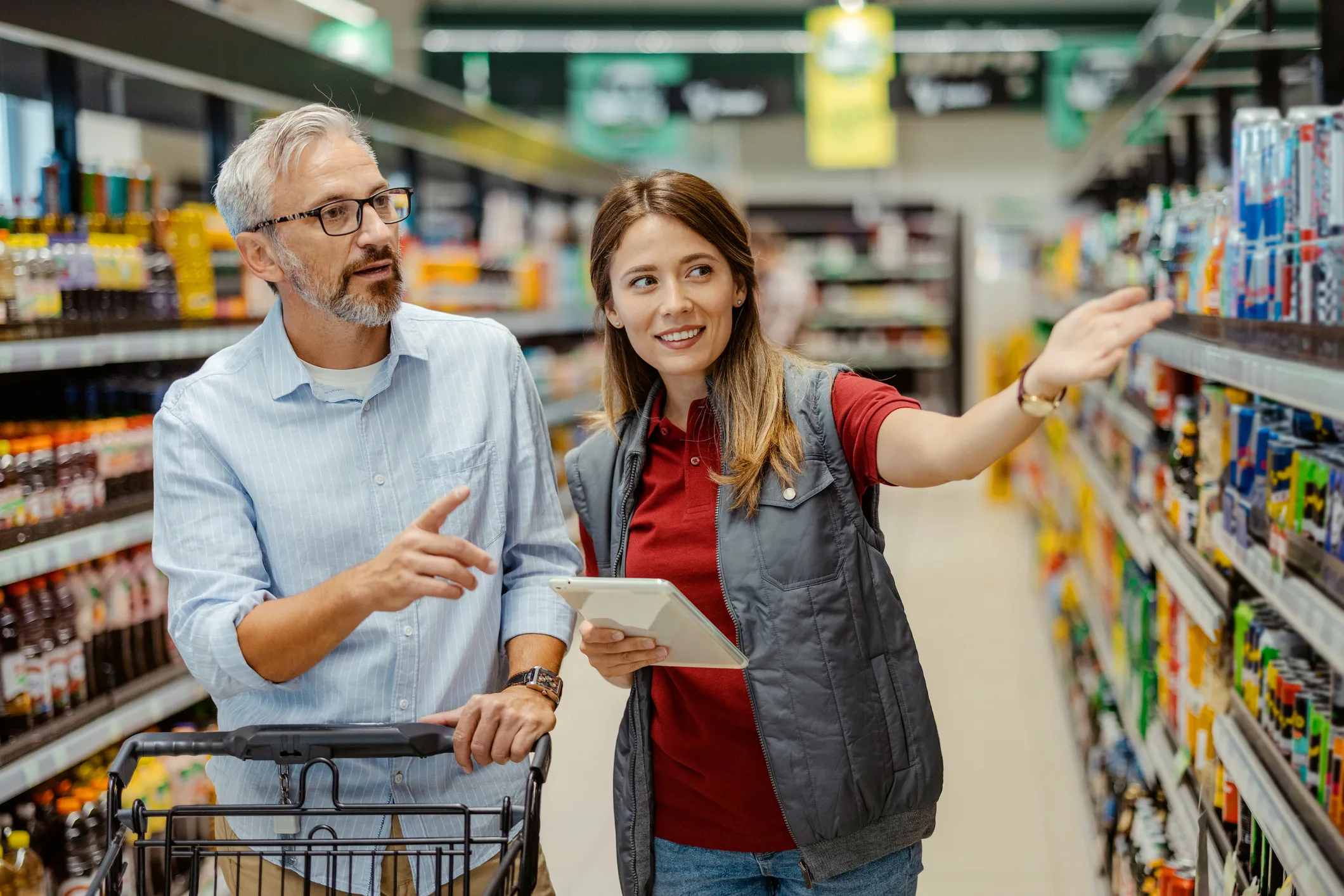 Female store manager talking to mature male customer in a grocery store