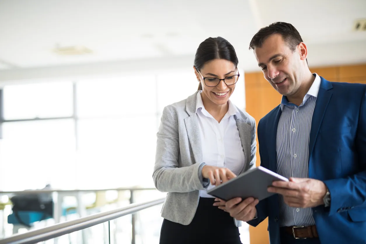 Two business people discussing business strategy using digital tablet